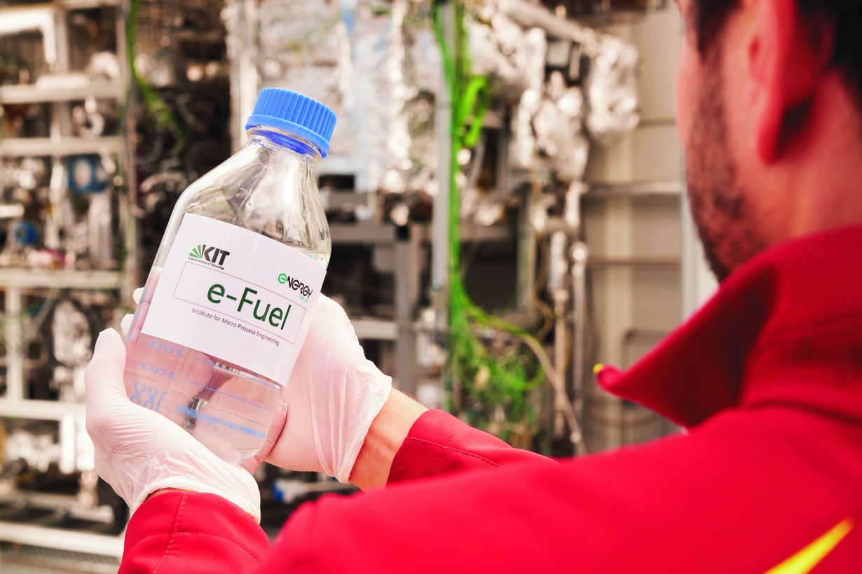 Flasche mit reFuels-Kraftstoff in den Händen eines KIT-Mitarbeiters